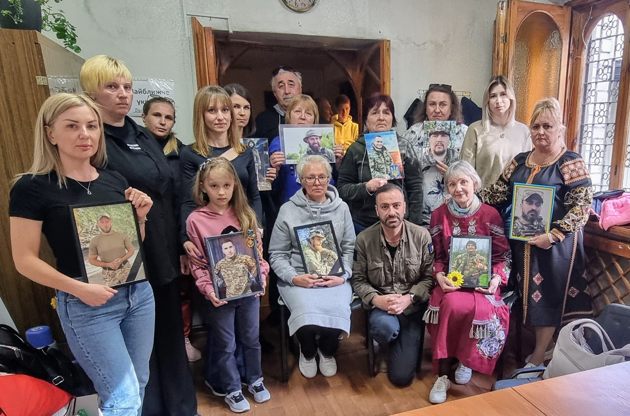 Familles tenant les photos de leurs proches